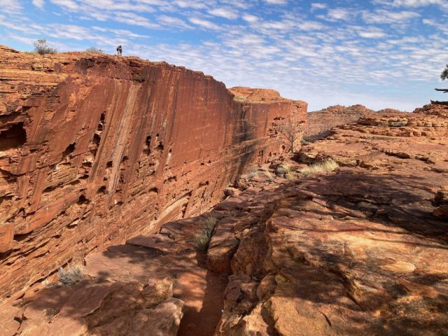 At the edge of the canyon in front of the cliffs on the other side At the edge of the canyon in front of the cliffs on the other side